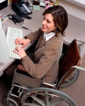 vrouw in rolstoel werkt aan computer
