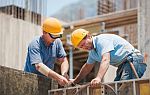 twee bouwvakkers werken aan constructie op bouwwerf