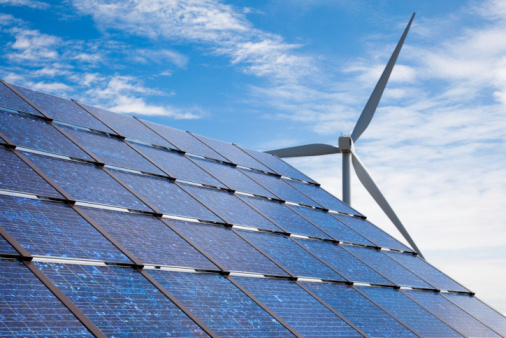 dak met zonnepanelen en zicht op een windmolen